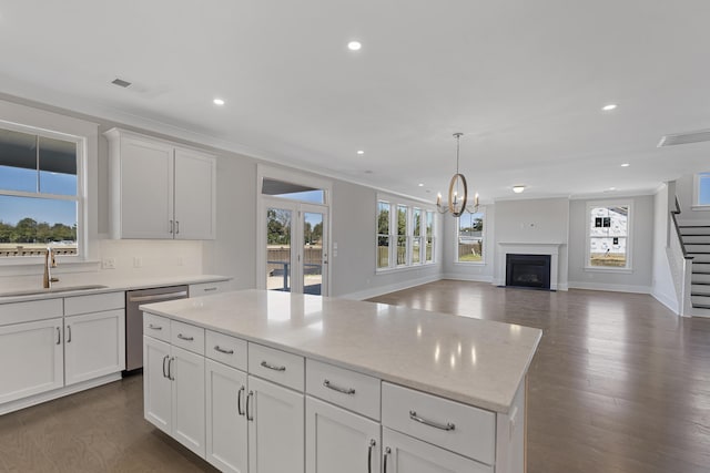 kitchen with white cabinetry, a center island, sink, and stainless steel dishwasher