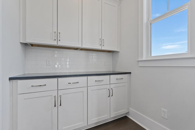 interior space with white cabinetry, dark hardwood / wood-style flooring, and decorative backsplash