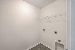 clothes washing area featuring tile patterned floors, hookup for a washing machine, and hookup for an electric dryer