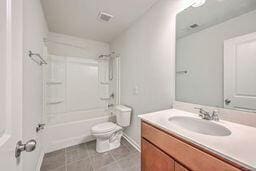 full bathroom featuring toilet, vanity, tile patterned flooring, and bathing tub / shower combination