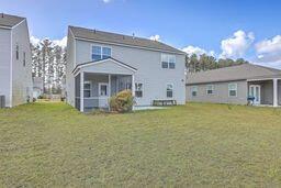 rear view of house with a sunroom and a yard