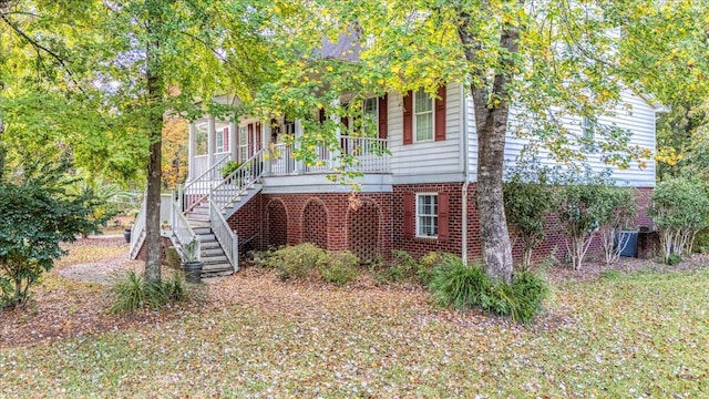 view of property hidden behind natural elements featuring a porch