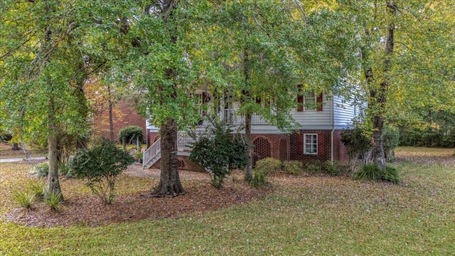 view of property hidden behind natural elements with a front yard