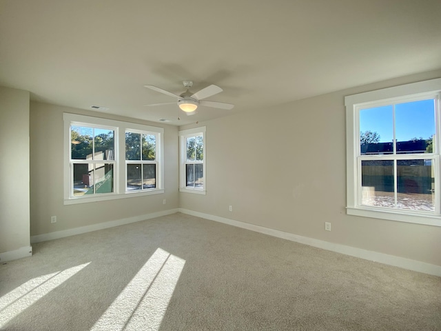 empty room featuring visible vents, light colored carpet, and baseboards