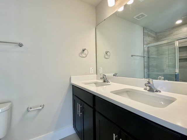 full bathroom with toilet, a stall shower, visible vents, and a sink