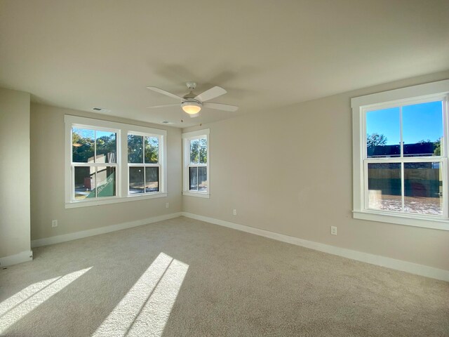 spare room featuring baseboards, visible vents, and light colored carpet