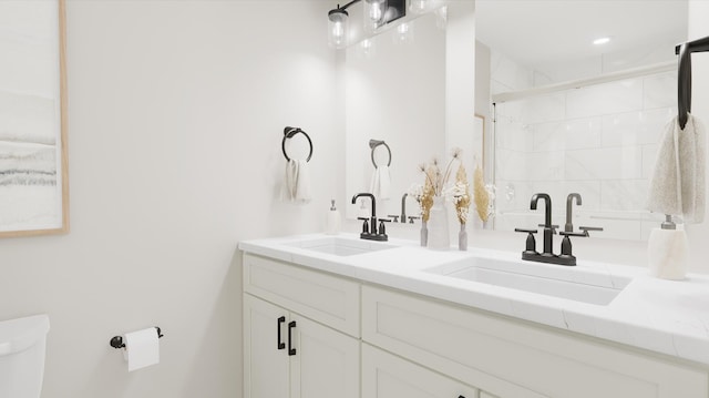 bathroom featuring a shower, a sink, toilet, and double vanity