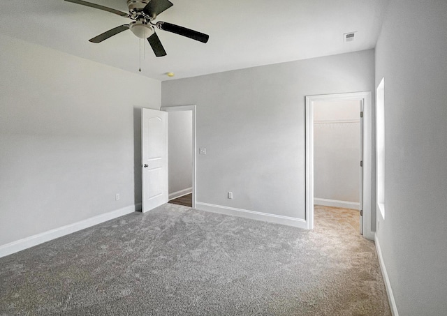 222 New Iris Ln, Ridgeville, SC 29472 - unfurnished bedroom featuring visible vents, baseboards, carpet floors, a ceiling fan, and a walk in closet