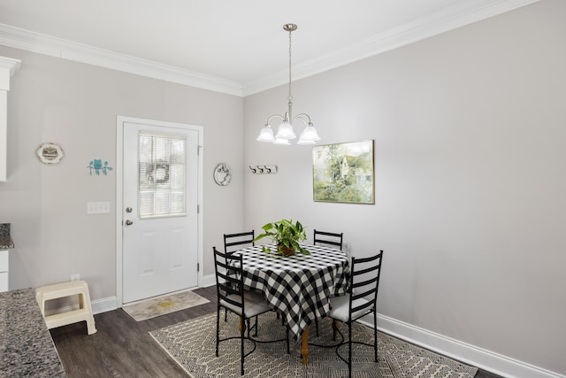 dining room with dark hardwood / wood-style floors, ornamental molding, and an inviting chandelier