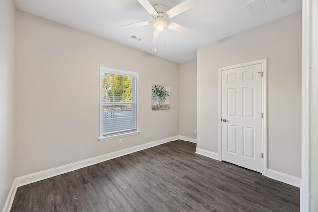 spare room with dark wood-type flooring and ceiling fan