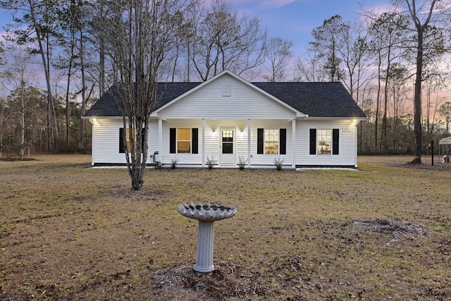 view of front facade featuring covered porch and a yard