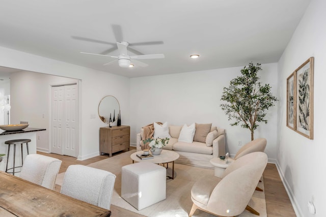 living room with ceiling fan and light hardwood / wood-style floors