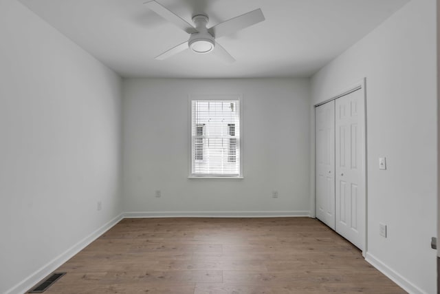 unfurnished bedroom with ceiling fan, a closet, and light hardwood / wood-style flooring