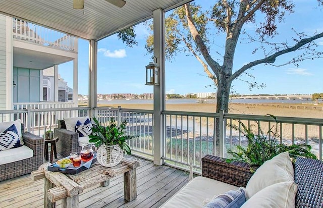 deck with a ceiling fan and a water view