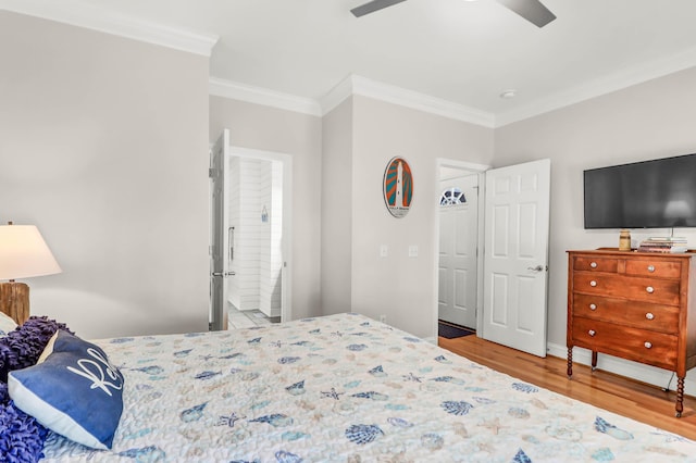 bedroom with a ceiling fan, crown molding, wood finished floors, and ensuite bath