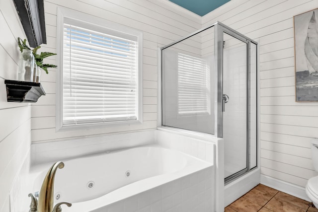 full bath featuring tile patterned flooring, toilet, a tub with jets, and a stall shower