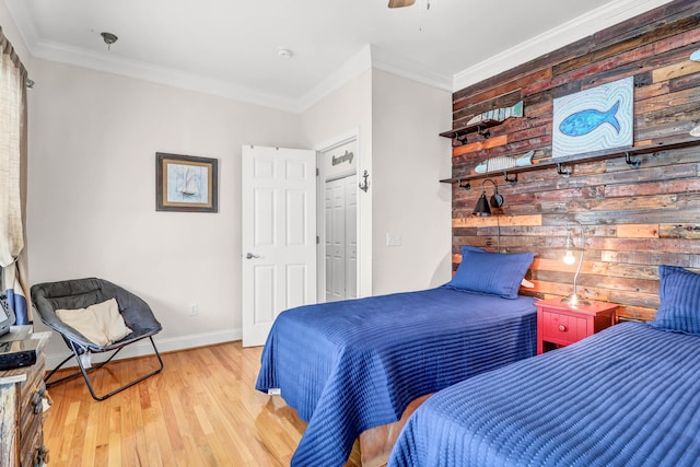 bedroom featuring baseboards, a ceiling fan, wood finished floors, and crown molding