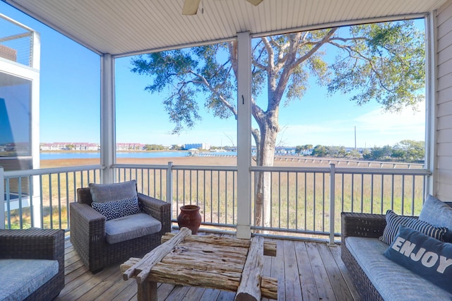 sunroom featuring a water view and ceiling fan