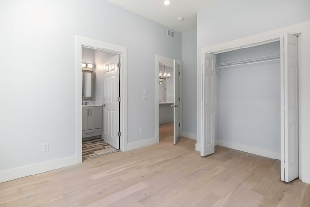 unfurnished bedroom featuring light hardwood / wood-style flooring, connected bathroom, and a closet