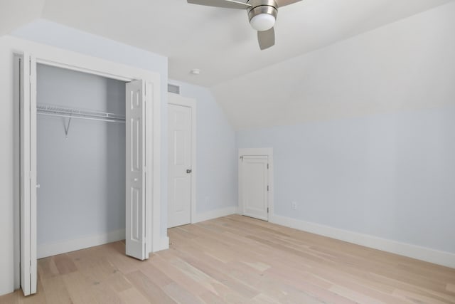 unfurnished bedroom with light hardwood / wood-style flooring, a closet, vaulted ceiling, and ceiling fan