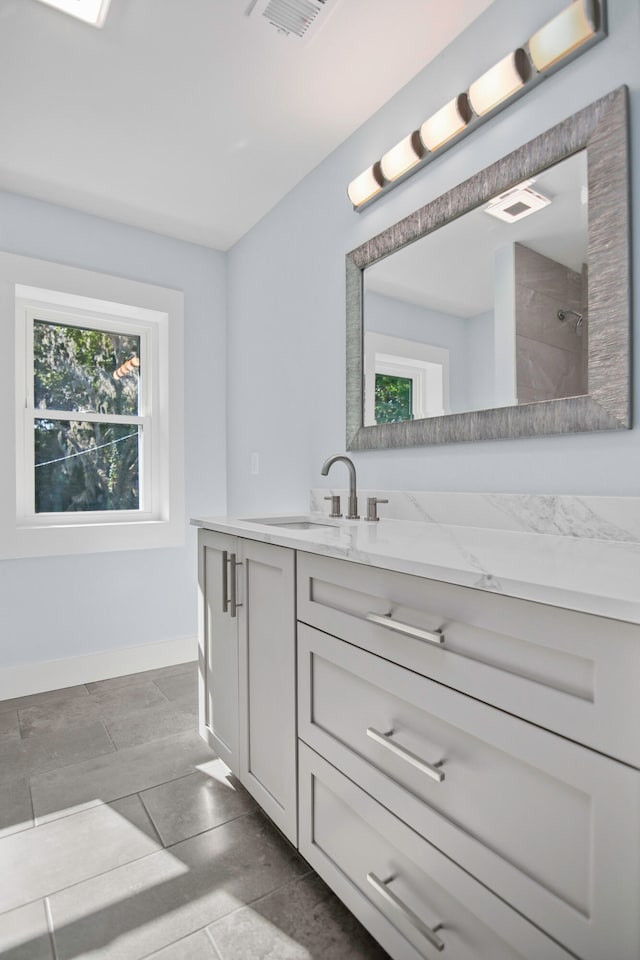 bathroom with a shower, vanity, and tile patterned floors