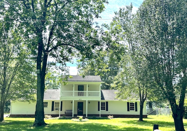 view of front facade featuring a balcony and a front yard