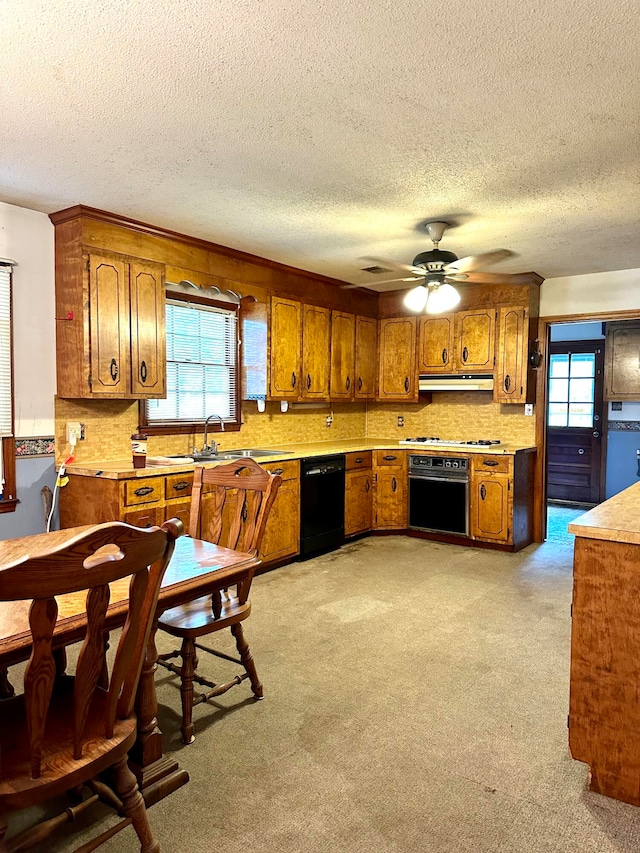 kitchen featuring a textured ceiling, light carpet, ceiling fan, sink, and black appliances