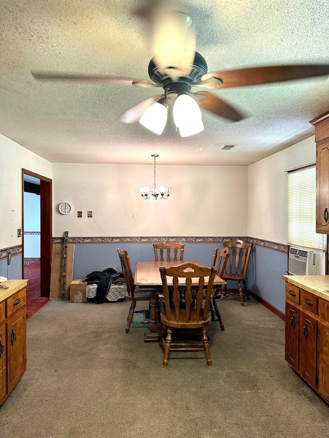 carpeted dining room featuring ceiling fan with notable chandelier and a textured ceiling