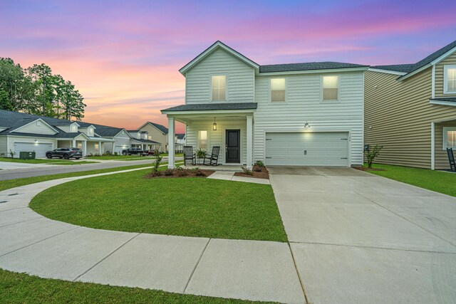 view of front of house with a porch, a garage, and a yard