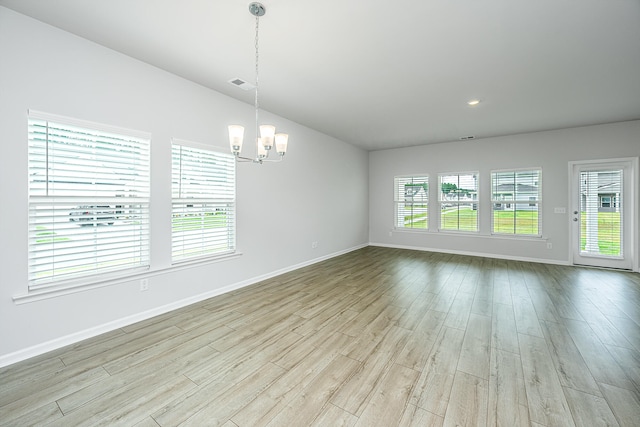 unfurnished living room featuring light hardwood / wood-style flooring and a notable chandelier