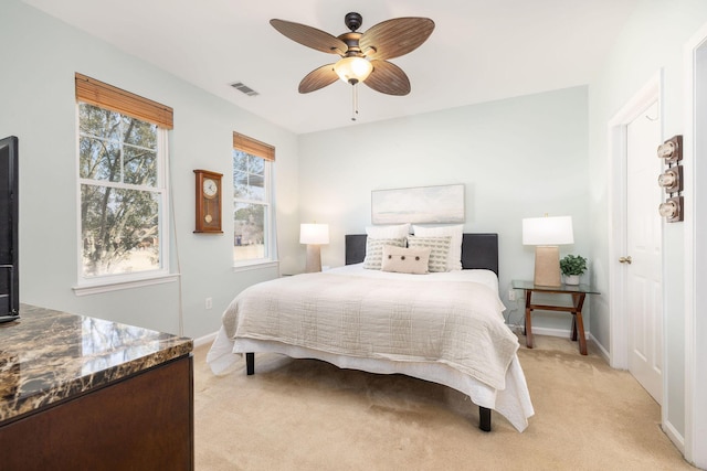 bedroom featuring baseboards, ceiling fan, visible vents, and light colored carpet