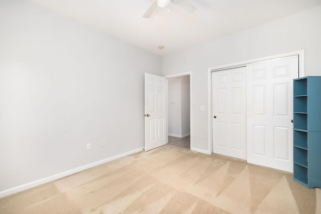 unfurnished bedroom with a ceiling fan, carpet, a closet, and baseboards