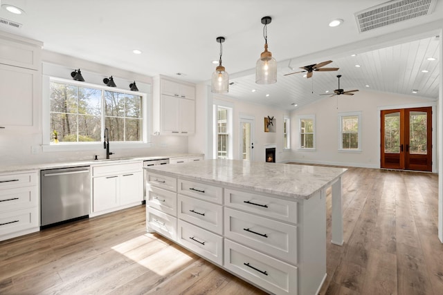 kitchen featuring a kitchen island, a sink, visible vents, white cabinetry, and stainless steel dishwasher