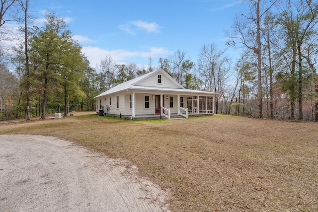 farmhouse inspired home featuring a sunroom, a porch, and a front yard