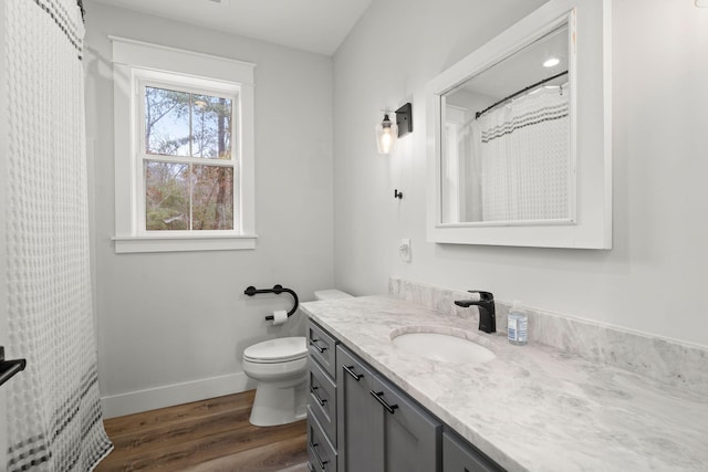full bathroom with toilet, vanity, baseboards, and wood finished floors