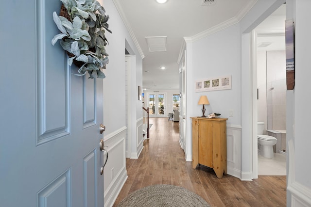 entrance foyer with a decorative wall, recessed lighting, wood finished floors, visible vents, and ornamental molding