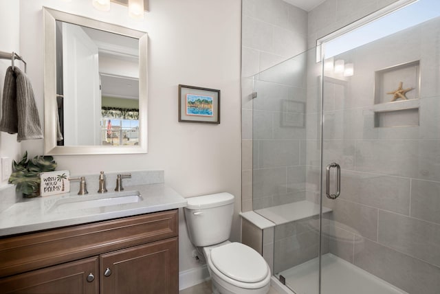 bathroom with toilet, a stall shower, plenty of natural light, and vanity