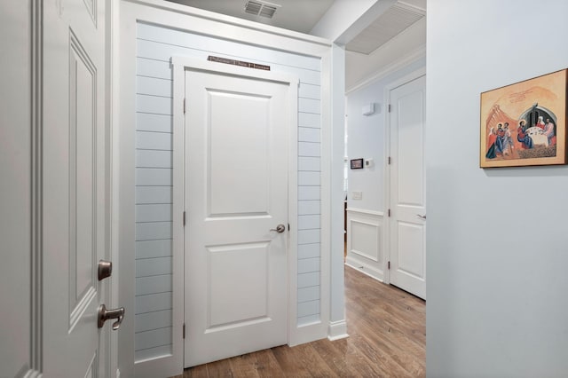 hallway featuring visible vents and wood finished floors