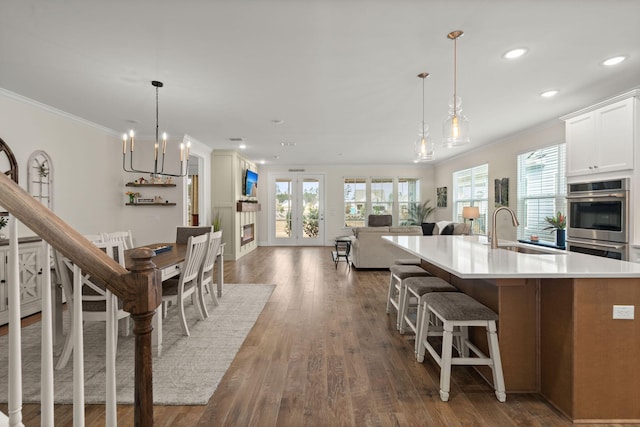 kitchen featuring a glass covered fireplace, dark wood-style flooring, a sink, and a healthy amount of sunlight