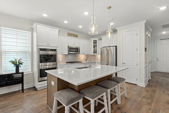 kitchen featuring stainless steel appliances, a sink, and ornamental molding