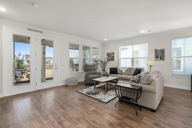 living room with ornamental molding, visible vents, baseboards, and wood finished floors