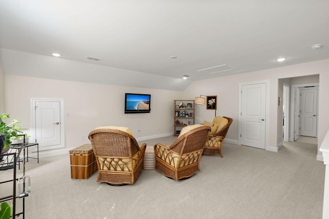 sitting room featuring light carpet, baseboards, visible vents, and vaulted ceiling