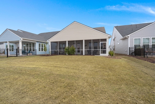 rear view of house featuring a sunroom, fence, and a lawn