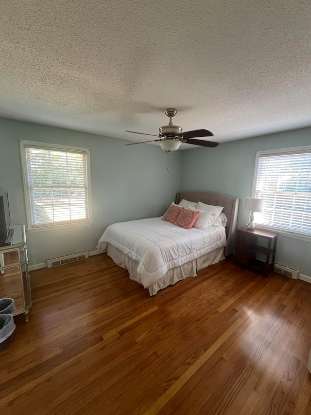 bedroom with a textured ceiling, hardwood / wood-style flooring, and ceiling fan