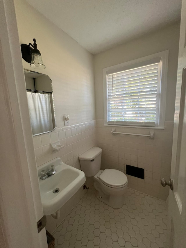 bathroom featuring tile walls, sink, toilet, and tile patterned flooring