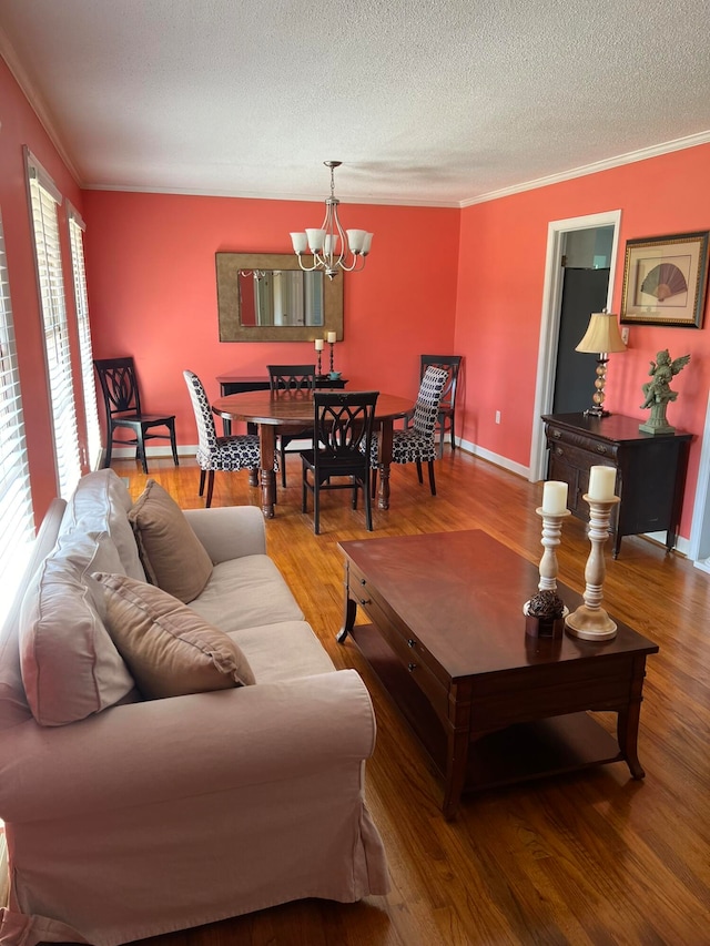 living room featuring crown molding, hardwood / wood-style floors, a chandelier, and a textured ceiling