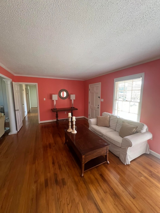 living room with a textured ceiling, hardwood / wood-style flooring, and decorative columns