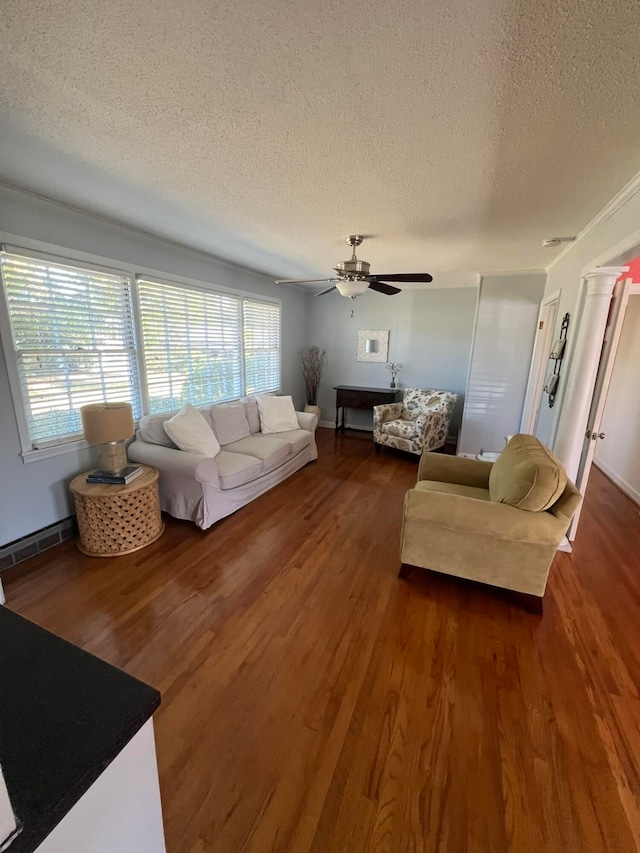 living room featuring dark wood-type flooring, ornate columns, a textured ceiling, and ceiling fan