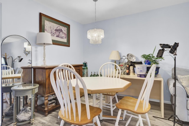 dining space with a dry bar, wood finished floors, and a chandelier