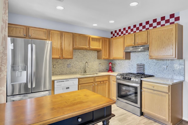 kitchen with tasteful backsplash, under cabinet range hood, recessed lighting, stainless steel appliances, and a sink